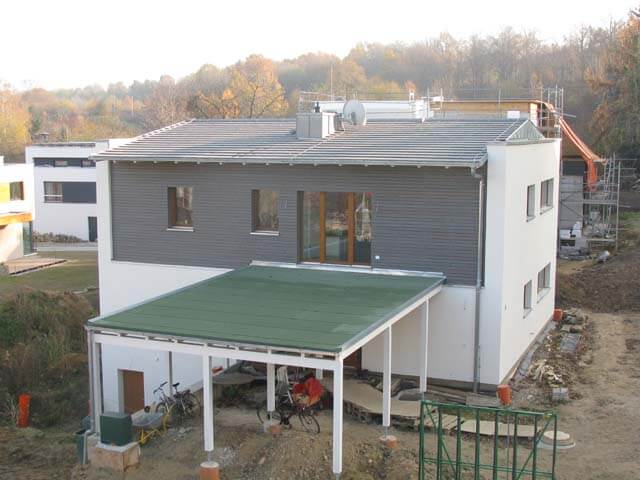 Modernes Wohnhaus mit grauem Dach und grünem Vordach, Einfamilienhaus Lotzestraße