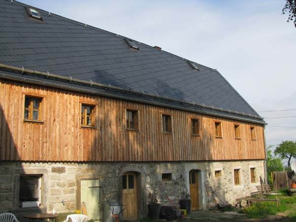 Fertiggestelltes Schieferdach an einem modernen Gebäude mit Holzfassade